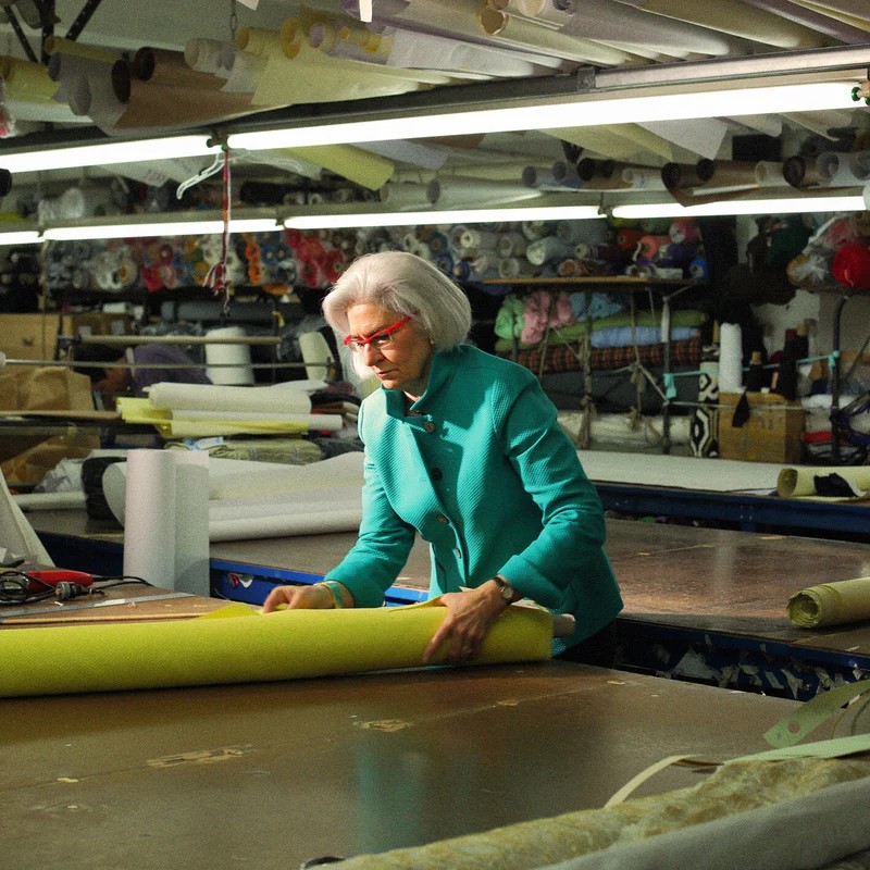 Nina McLemore leans over fabric on a table