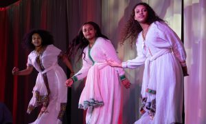 Students dressed in cultural attire dance at a cultural event