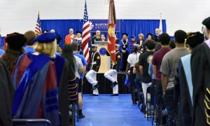 Students and faculty stand as the color guard enters during convocation