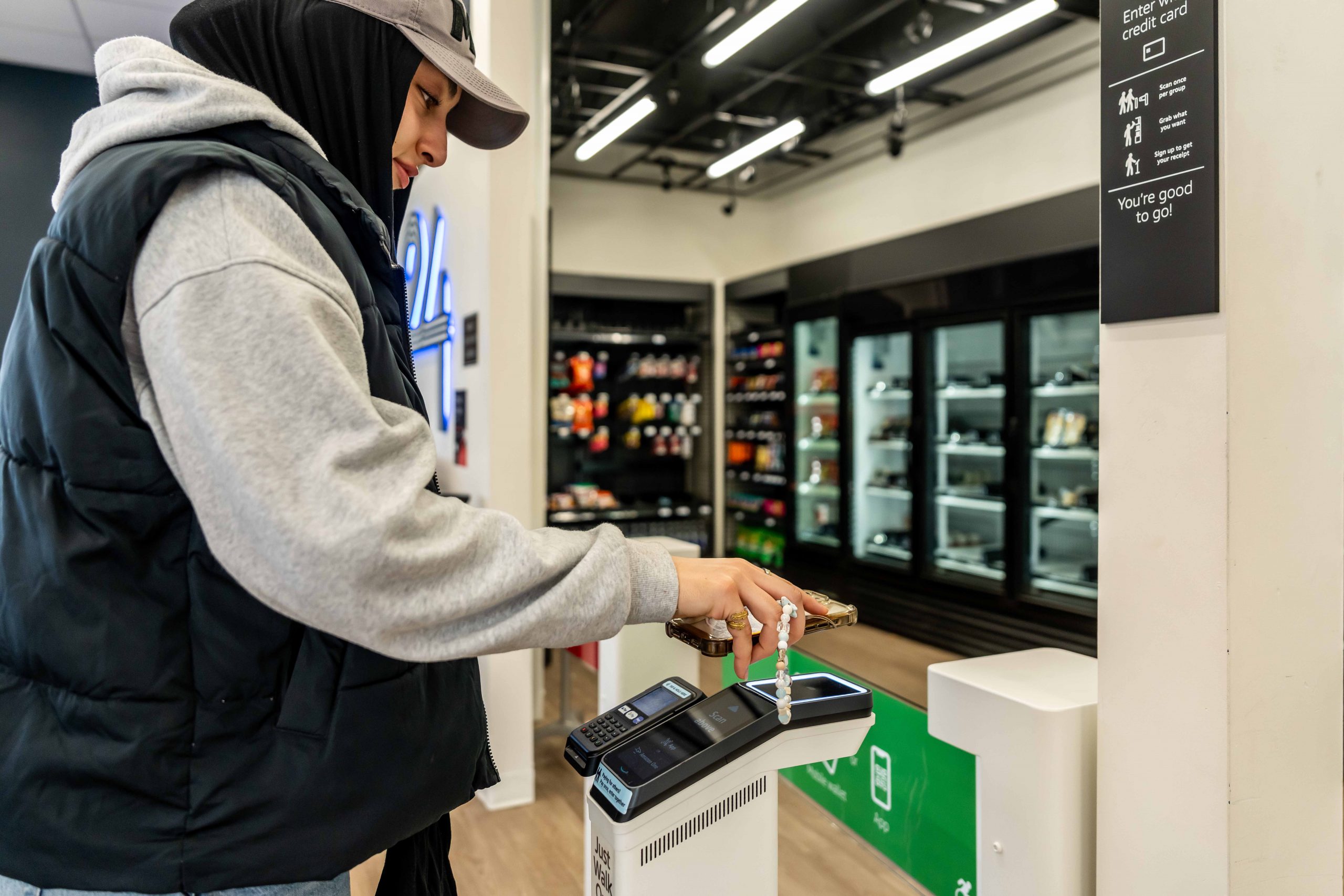 Student scans phone to enter Saints 24 market with "just walk out" technology.