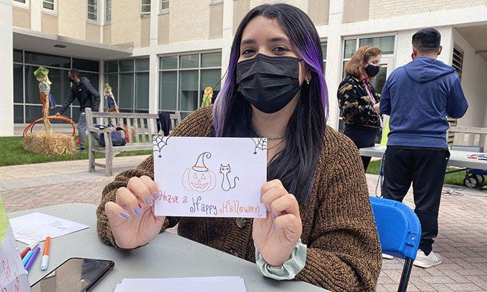 A Marymount student writes a note during Halloween Fest