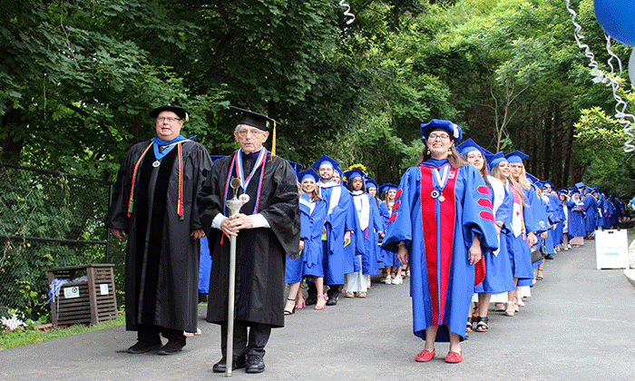 Lavanty holding the mace as Marymount's 2023 Commencement begins.