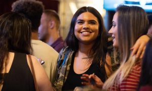 A girl smiles through a crowd.