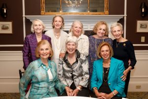A group of older women alumni pose in two rows for a photo. The first row has three women sitting. The second row has give women standing.