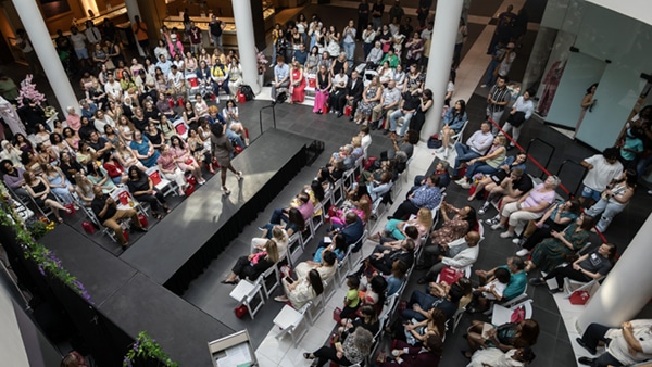 Marymount students walk on a runway at the Pentagon City Fashion Centre in front of a packed audience.