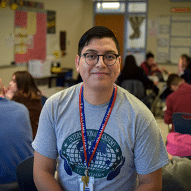 Onelio Aguilar poses for a photo in a high school classroom.