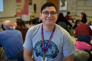 Onelio Aguilar poses for a photo in a high school classroom.