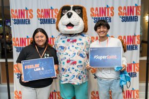 Students smile next to Bernie the mascot.