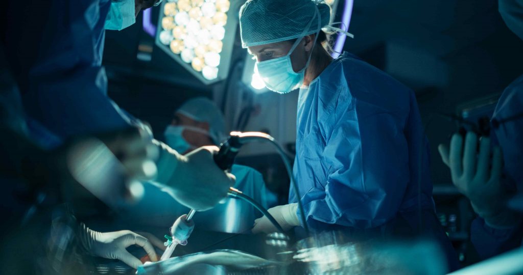 Specialized nurses in scrubs and masks assist in an operating room