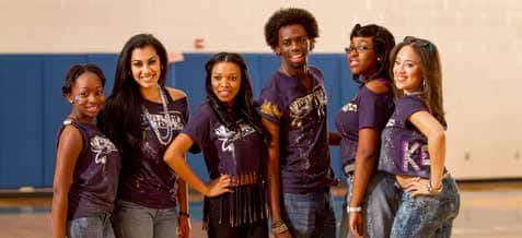 Students in matching shirts pose together.