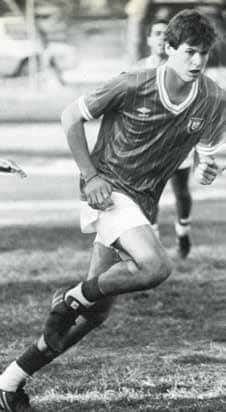 A soccer player in uniform runs down a field.