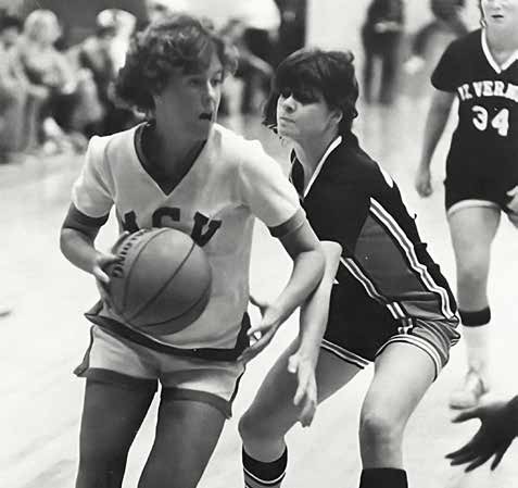 A student athlete dribbles down the court while defended by another player.