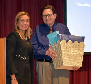 President Becerra stands besides Dr. Louis Frisenda and he holds a congratulatory award basket.