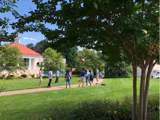 Students stand in a circle hitting a beach ball to each other