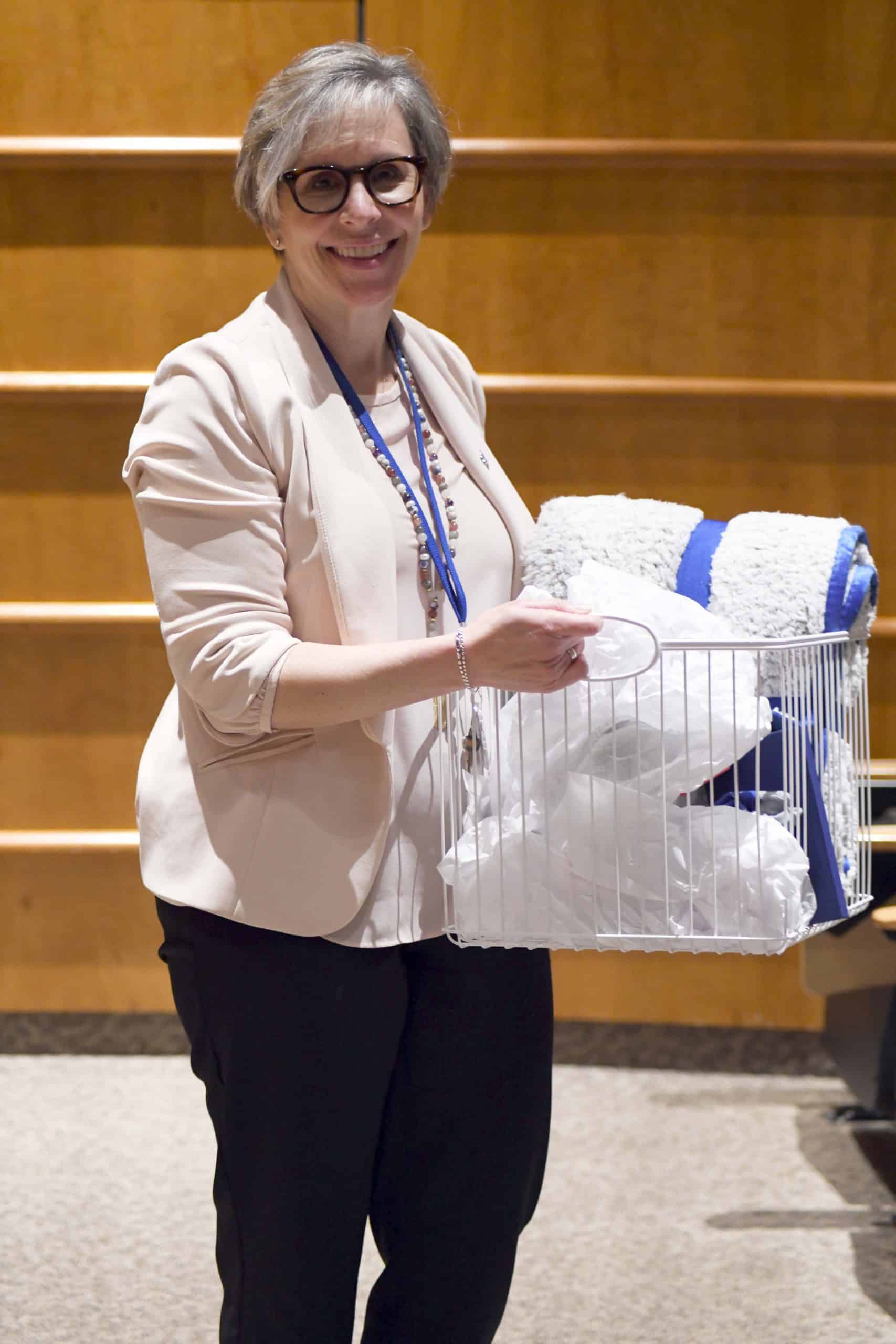 Dr. Amy Allnutt holds a congratulatory basket with Marymount paraphernalia.